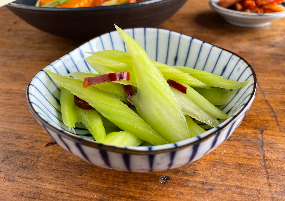 Japanese Pickled Celery Asazuke with tteokbokki and kimchi in background