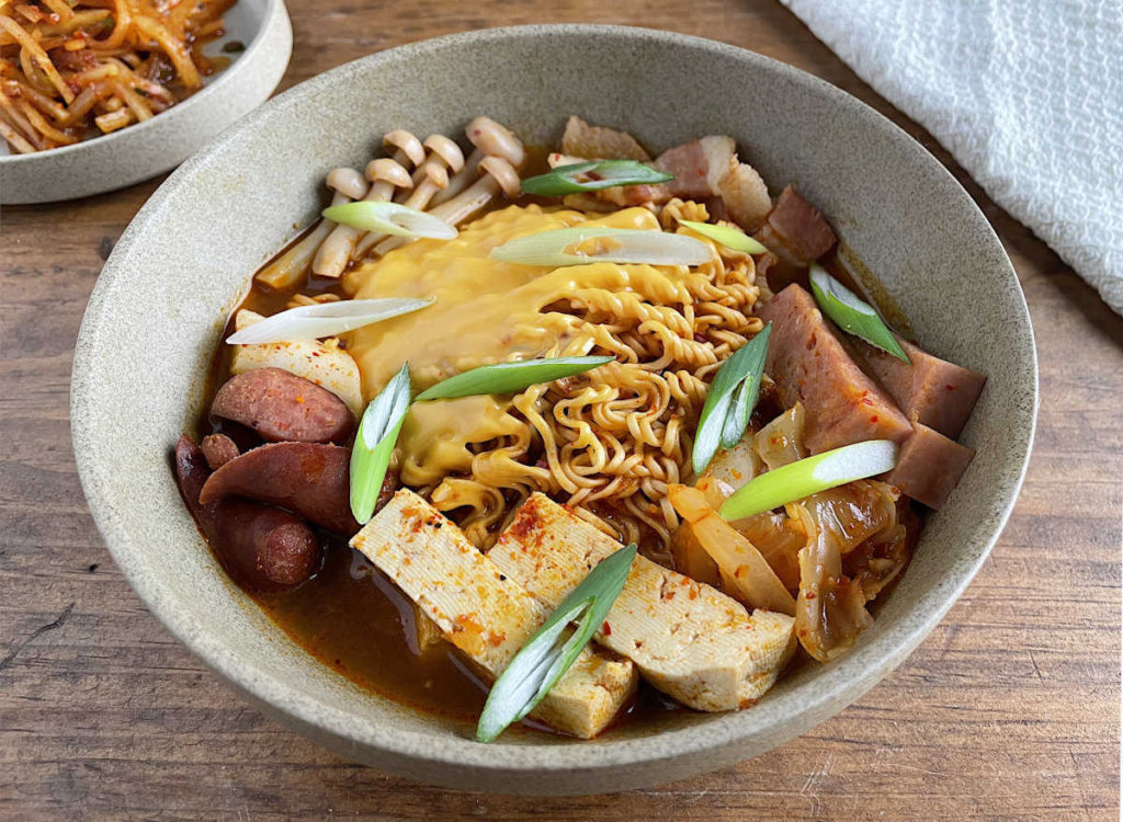 Korean army stew in a tan bowl