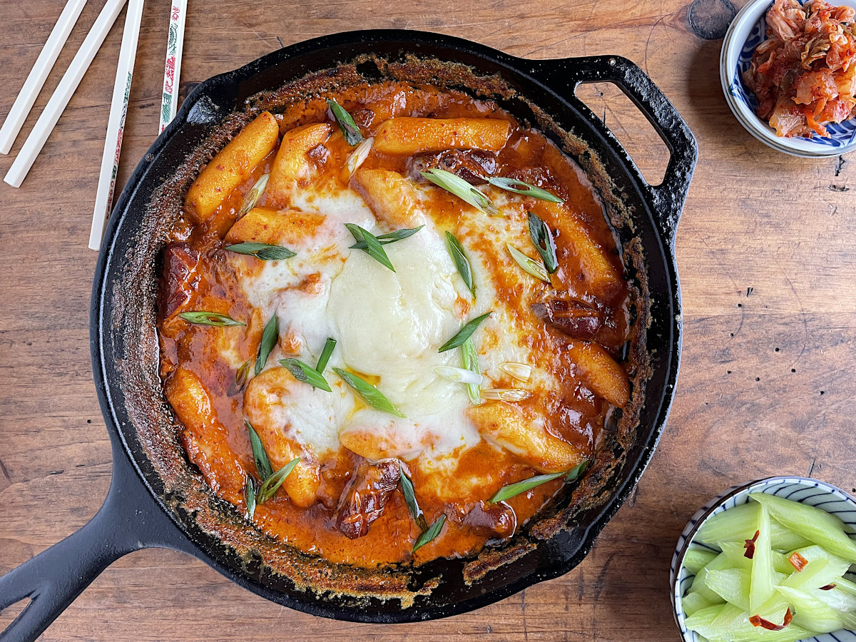 Rose tteokbokki without fish cakes in cast iron pan with celery on side