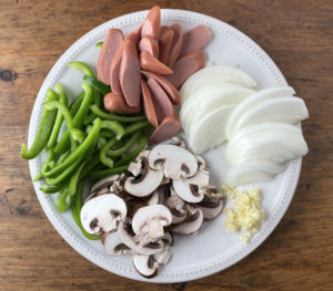 Sliced onions, bell pepper, mushrooms and hot dogs for recipe