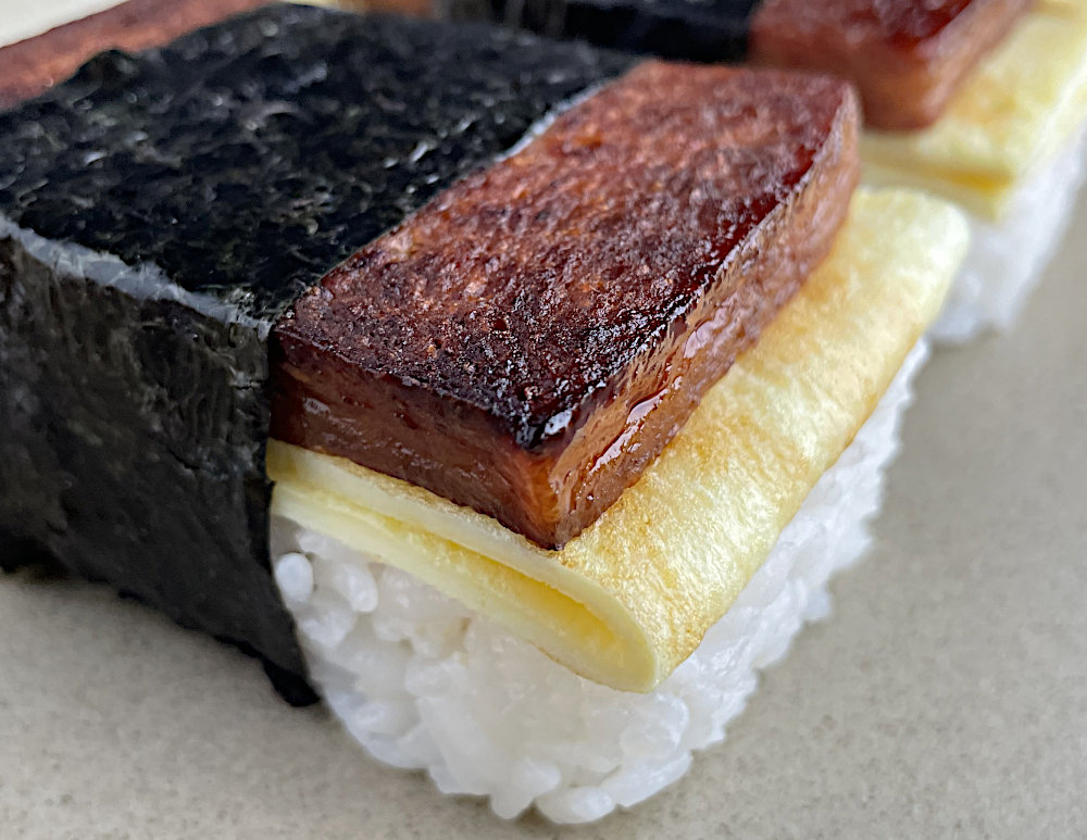 Spam musubi with egg on a tan plate