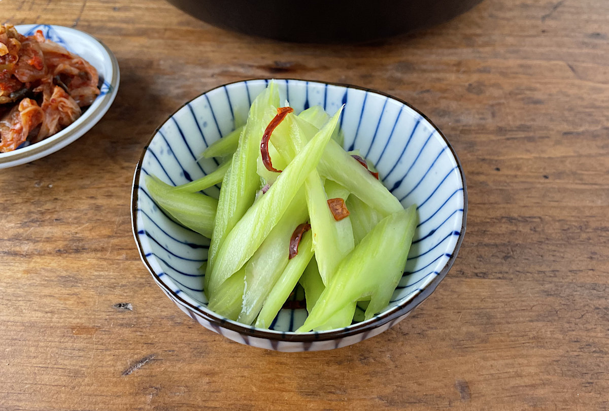Japanese Pickled Celery Asazuke in a small bowl with kimchi in background