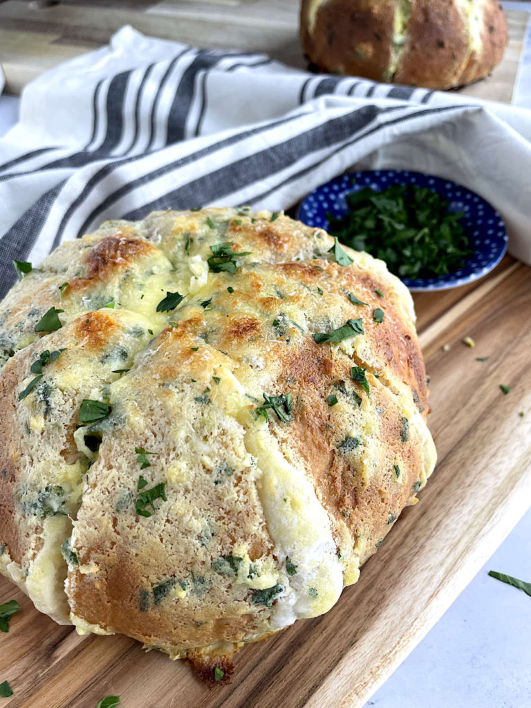 Cream cheese bread on a cutting board with more bread in background